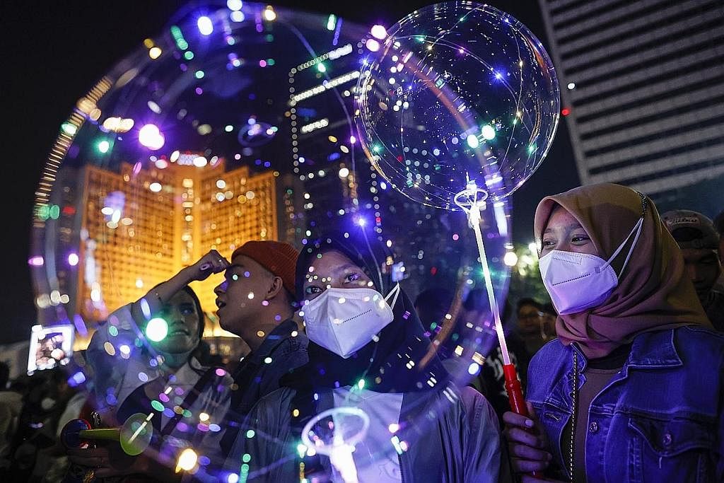MERIAH: Orang ramai berkumpul untuk sambutan Tahun Baru di bulatan utama di Jakarta, Indonesia sedang negara itu secara rasmi menarik balik sekatan berkaitan Covid-19. - Foto EPA-EFE