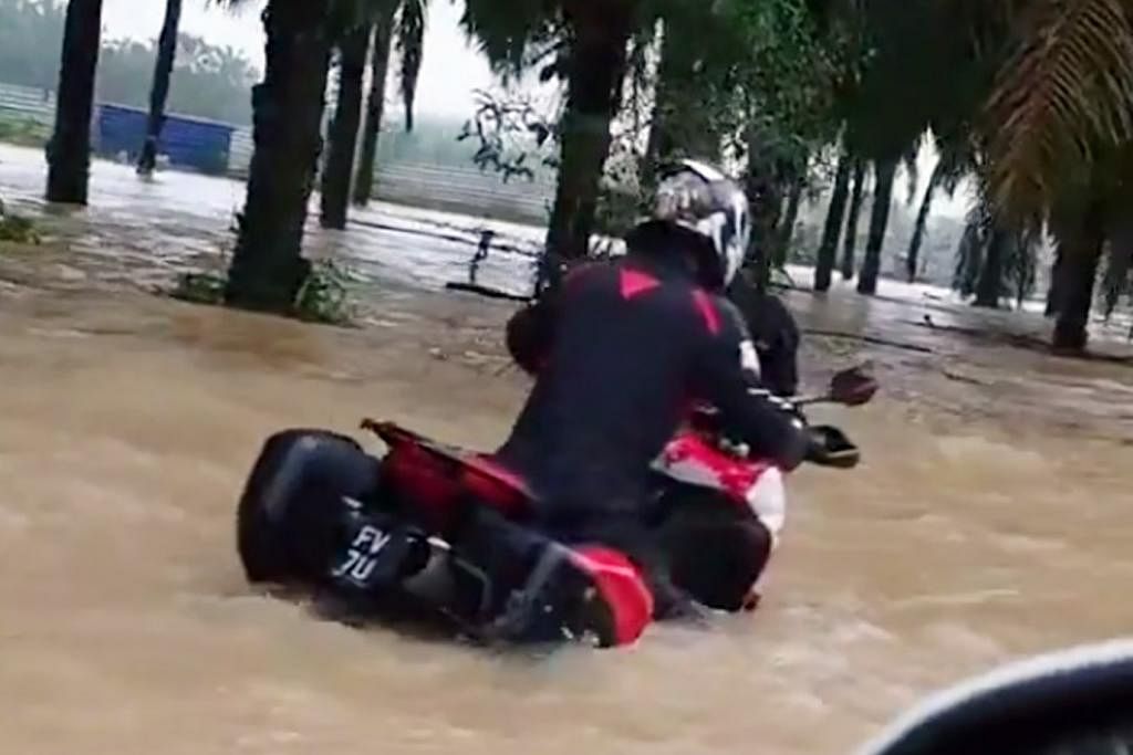 REDAH BANJIR: Sebuah  motosikal  berkuasa tinggi  dari Singapura  terperangkap  dalam arus  deras ketika  meredah banjir  di Jalan Nitar,  Mersing  semalam. – Foto  FACEBOOK  KOMUNITI  JOHO