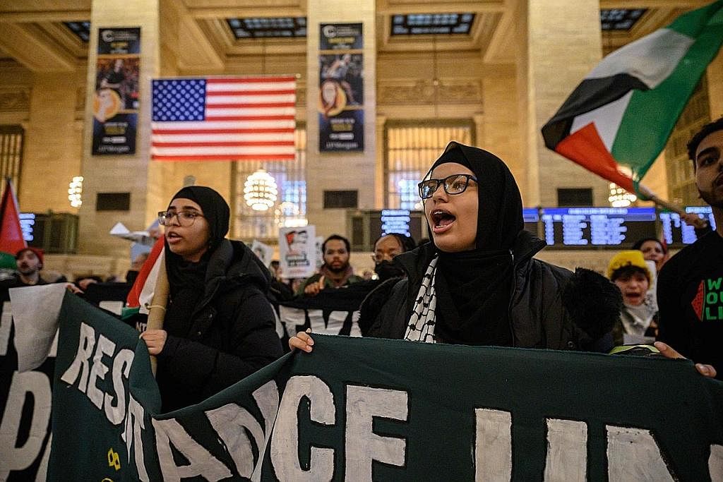TUNJUK RASA: Aktivis pro-Palestin berhimpun di Terminal Grand Central di New York, Amerika Syarikat, pada Januari 2022. - Foto AFP RAJA SALMAN BIN ABDULAZIZ AL SAUD: (Gambar sisipan) Juga menekankan peri penting menghidupkan semula proses damai di Ti