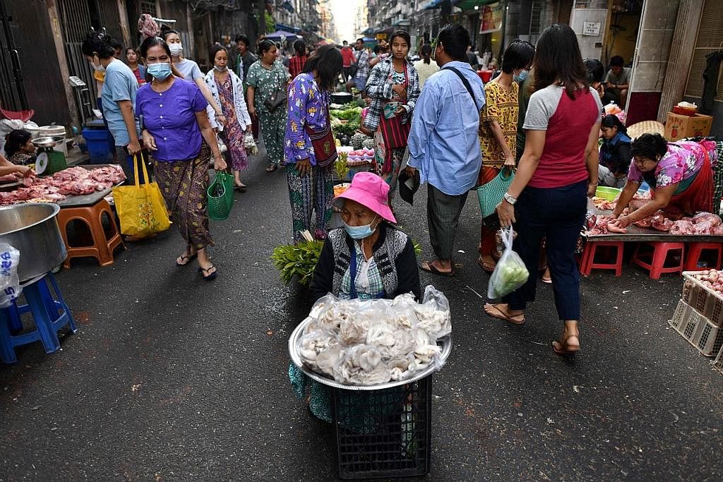 TENANG SEMENTARA: Rakyat Myanmar kelihatan sibuk berbelanja di jalanan kawasan pasar di Yangon, Myanmar, semasa keadaan reda daripada konflik yang bergolak sejak dua tahun lalu. - Foto AFP