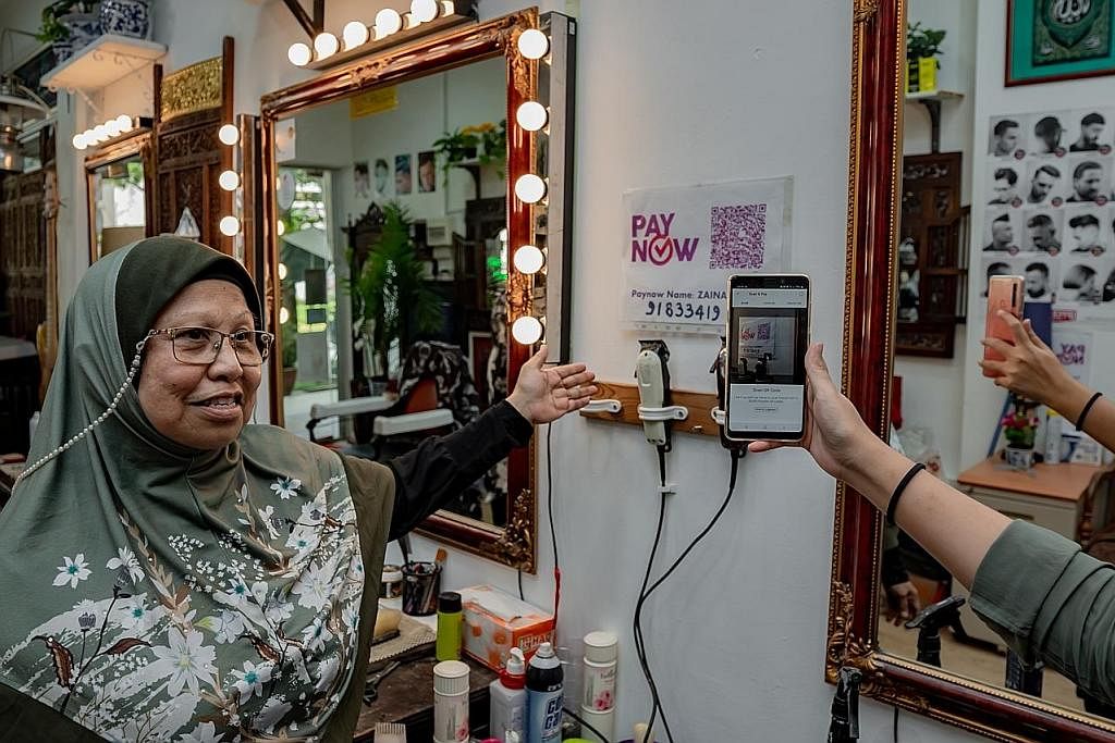 BAYAR SECARA DIGITAL: Pelanggan kedai gunting rambut Haji Osnam di Blok 239 Yishun Ring Road, yang dimiliki Cik Zainap Zainal Abidin bersama suami, boleh membayar menggunakan PayNow. Cik Zainap telah menyertai kursus untuk belajar tentang penggunaan 