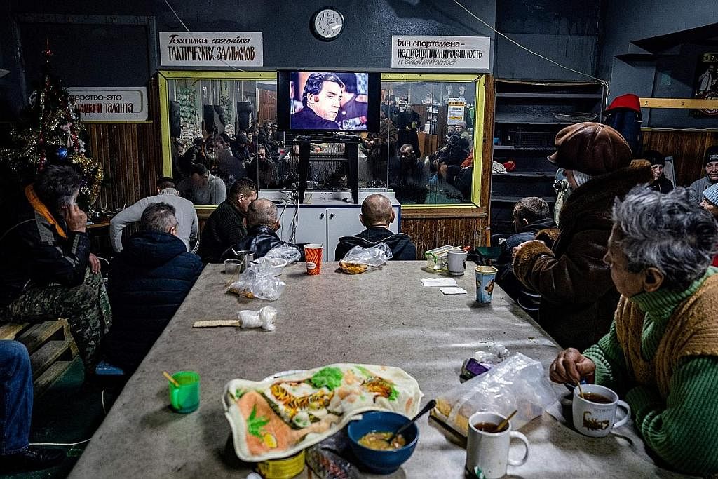 DALAM LINDUNGAN: Sekumpulan rakyat Ukraine menonton filem di pusat bantuan kemanusiaan di Bakhmut pada 27 Februari lalu di tengah-tengah pencerobohan Russia ke atas Ukraine. - Foto AFP HADAPI SERANGAN RUSSIA: Seorang penduduk tempatan melihat banguna