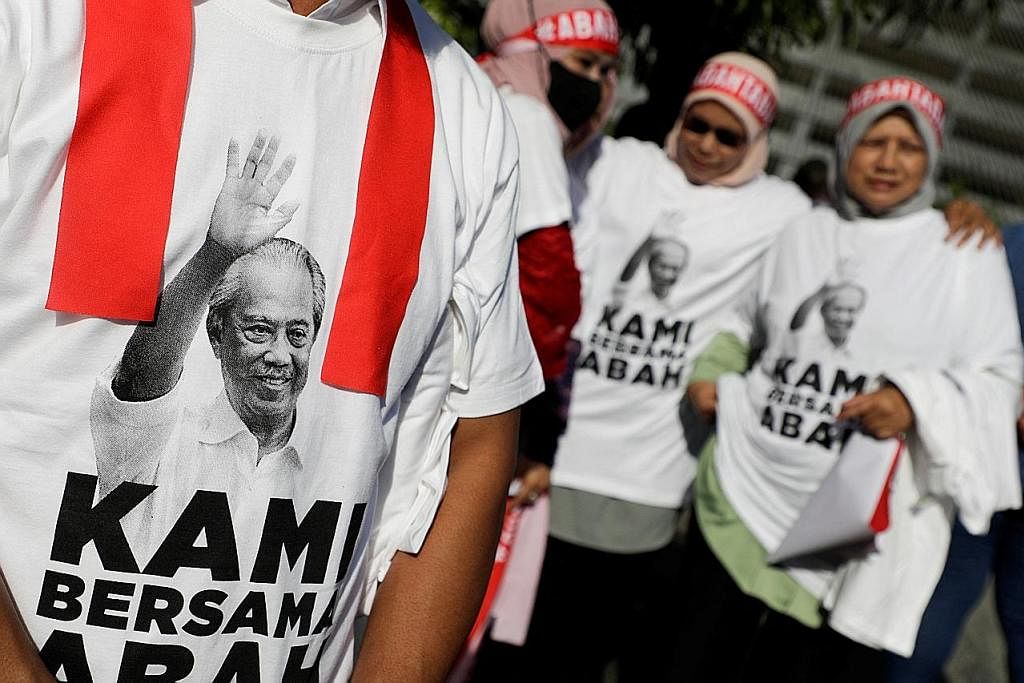 TUNJUK SOKONGAN: Penyokong PN hadir di Kompleks Mahkamah Kuala Lumpur pada Jumaat dengan memakai kemeja-T tertera gambar Tan Sri Muhyiddin dan slogan 'KAMI BERSAMA ABAH', nama julukan beliau semasa menjadi perdana menteri. - Foto REUTERS