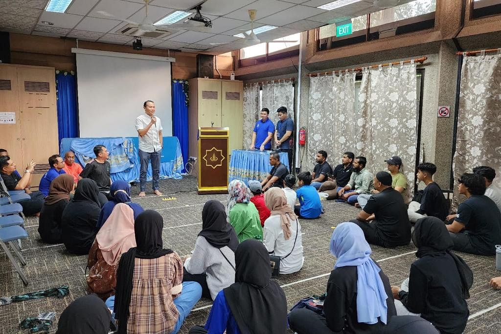 MENGGALAK SUKARELAWAN BELIA: Mayor CDC South East, Encik Mohd Fahmi Aliman, memberi ucapan kepada 70 belia MudaSG yang meluangkan masa untuk membantu membersihkan Masjid Darul Aman pada Sabtu pagi. – Foto MUDASG