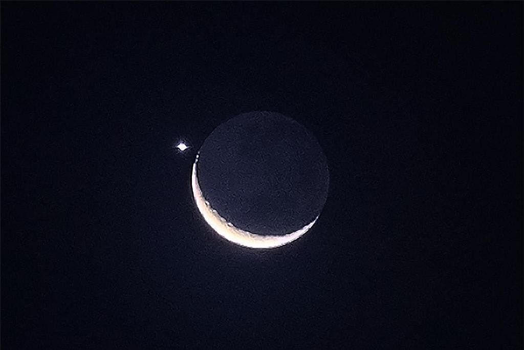 HIASI LANGIT MALAM: Pemandangan bulan sabit diiringi planet Zuhrah menghiasi langit malam pada Jumaat, 24 Mac. - Foto ST