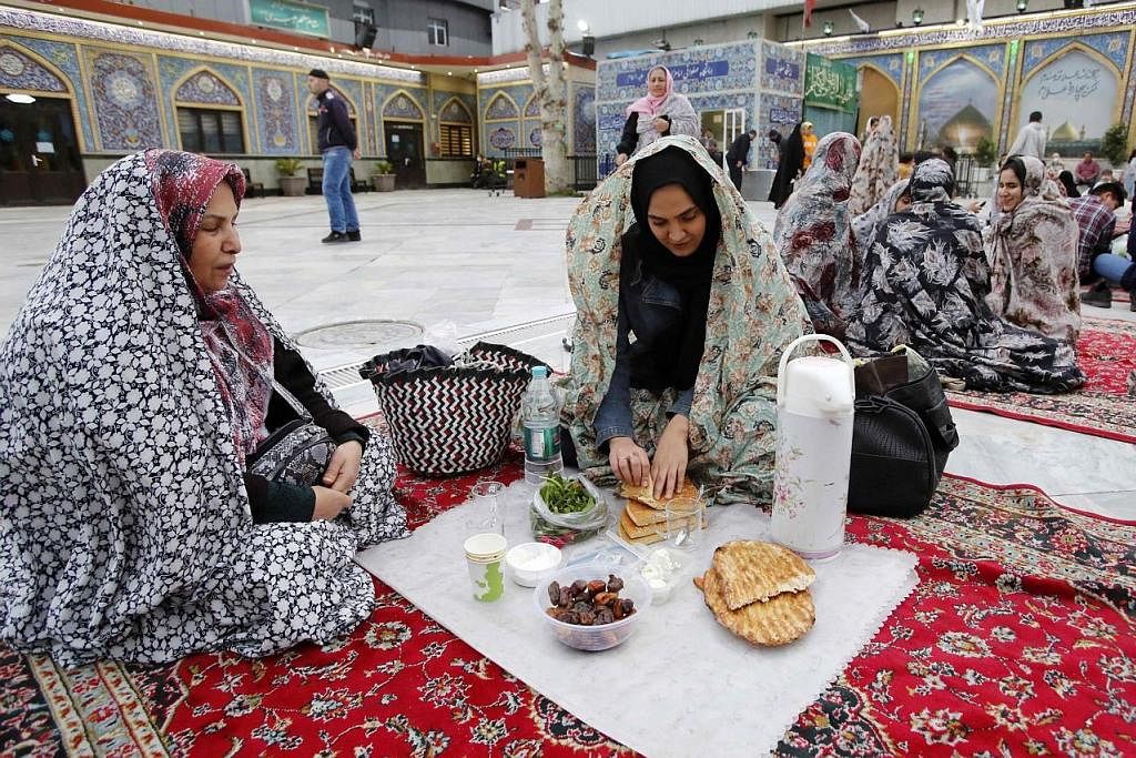 JUADAH IFTAR: Seorang relawan dari Yaman menyediakan juadah buka puasa di ibu kota Sanaa pada Isnin. - Foto-foto AFP BERKUMPUL: Keluarga di Iran ini berkumpul untuk membuka puasa pada Isnin di Emamzadeh Saleh di Teheran, Iran.