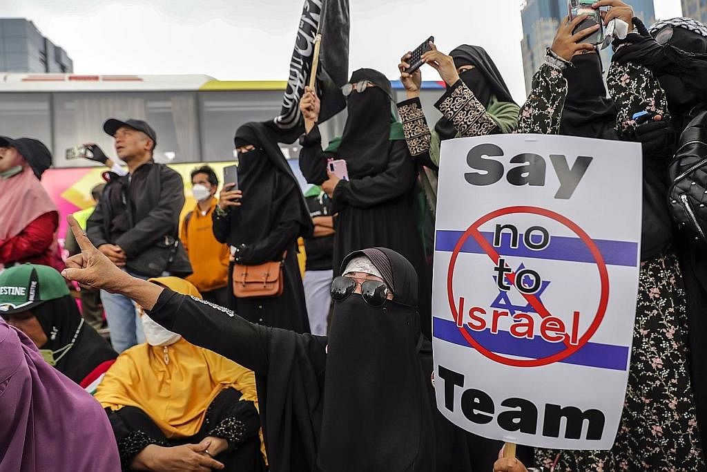 BANTAH: Penunjuk perasaan menuntut pemerintah Indonesia menolak penyertaan pasukan kebangsaan Israel dalam Piala Dunia FIFA Bawah-20 tahun, yang akan dianjurkan oleh Indonesia di enam bandar. - Foto EPA-EFE