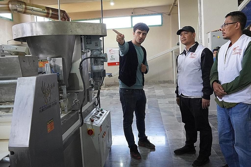 SEDIAKAN MAKANAN: Salah satu projek , Pengagihan Roti Syria, menawarkan roti segar kepada lebih 100,000 benefisiari. (Dari kanan) Ahli lembaga RLAF, Encik Mohamad Helmy Mohd Isa, dan Ketua Pegawai Eksekutif RLAF, Encik Muhammad Faizal Othman, mengunj