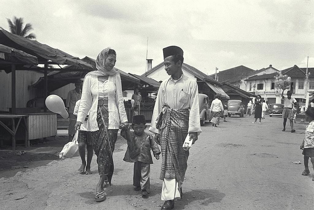 BERKUNJUNG-KUNJUNGAN DI HARI RAYA: Gambar dari tahun 1952 ini menunjukkan Encik Suhaimi Samian bersama isteri dan anaknya dalam perjalanan pulang ke rumah mereka di Geylang Serai selepas sehari suntuk berkunjungan ke rumah saudara-mara. - Foto fail K