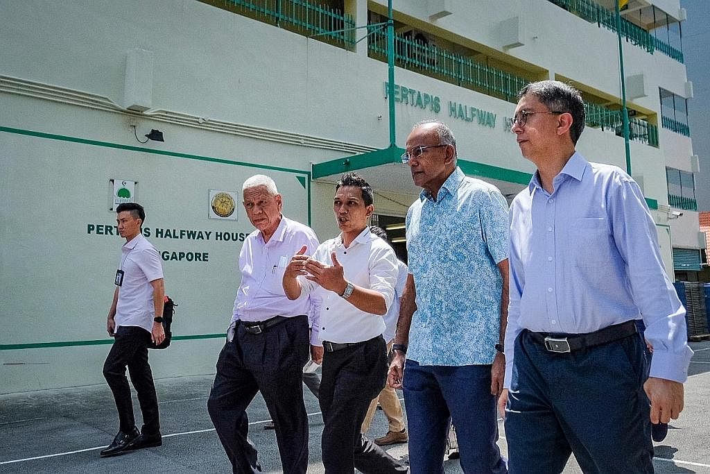 LAWAT RUMAH PERALIHAN: Semasa lawatannya ke Rumah Peralihan Pertapis, Encik K. Shanmugam (dua dari kanan), mengumumkan penubuhan Jawatankuasa Antara Kementerian (IMC) baru mengenai pencegahan dadah untuk belia. Turut bersama beliau ialah Menteri Nega