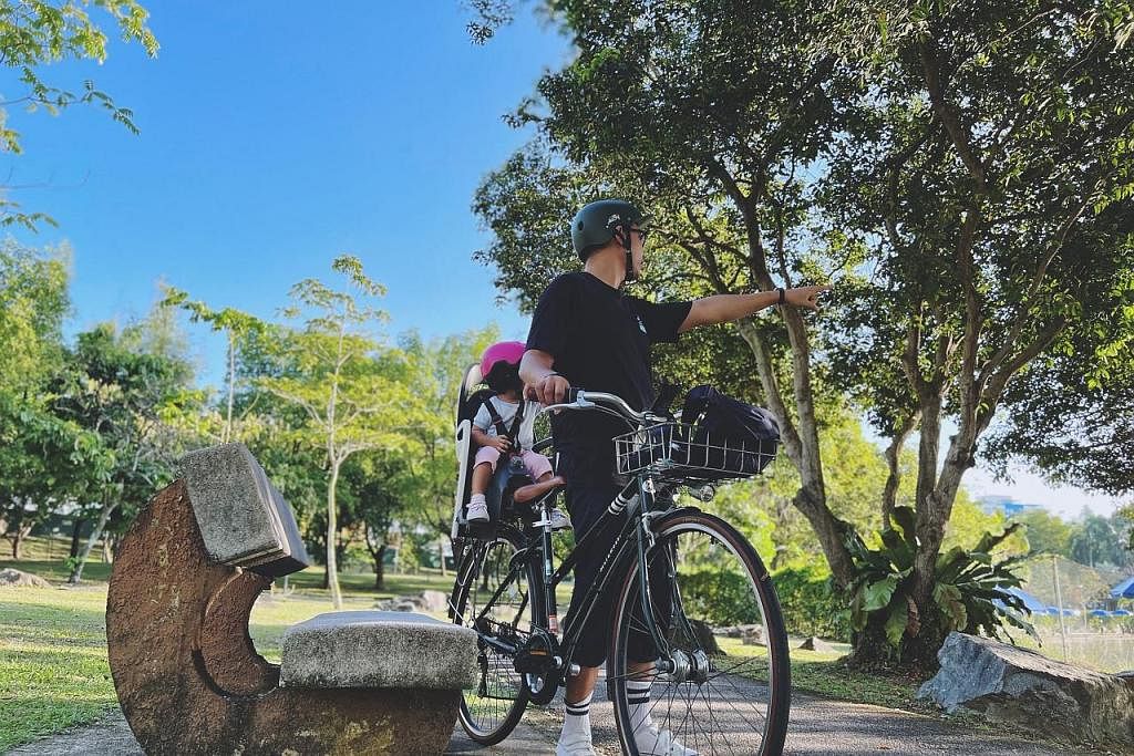 TEROKA BERSAMA ANAK DENGAN BASIKAL: Penulis bersama anaknya (dibonceng di belakang) di taman Pasir Ris Town Park dengan basikal khas bagi kegiatan itu. - Foto BH oleh HARITH MUSTAFFA