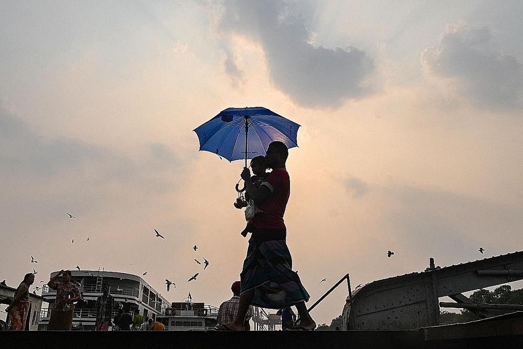 HADAPI GELOMBANG HABA: Myanmar merupakan salah sebuah negara yang mengalami kesan teruk daripada El Nino serta gelombang haba. Gambar menunjukkan seorang individu di Myanmar yang berteduhdi bawah payung daripada sinaran matahari. - Foto AFP